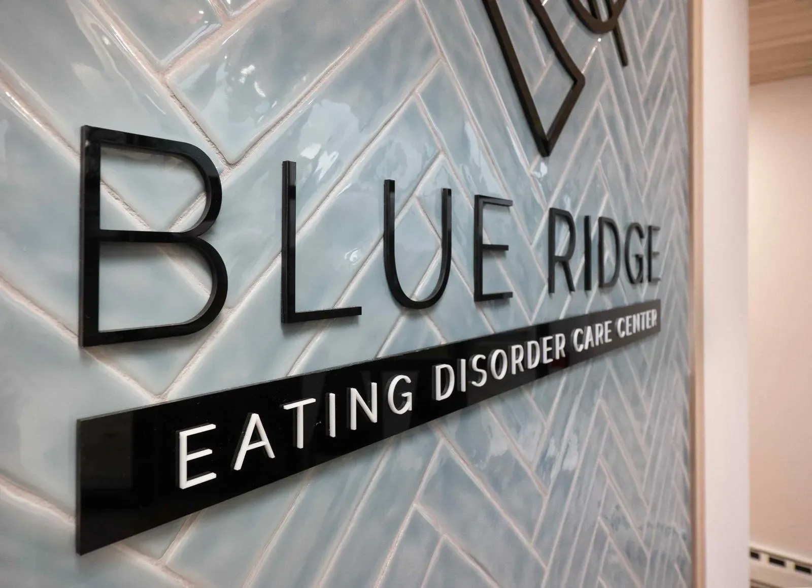 The image shows a sign on a wall with text that reads BLUE RIDGE at the top, followed by Eating Disorder Center, indicating the name of an organization related to eating disorders.